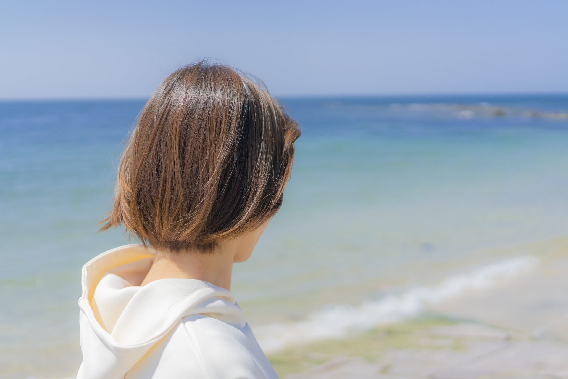 海を見る女性の後ろ姿のイメージ画像